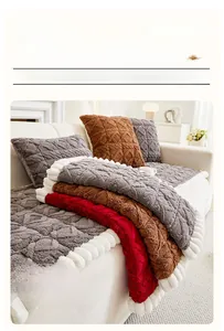 Detail of plush quilted sofa covers with decorative pom-poms showing machine washable fabric