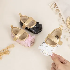 Detailed close-up of soft-sole baby Mary Jane shoes with hollow floral patterns and bows