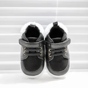 Detail of warm black baby boots with white faux fur lining and velcro strap closure