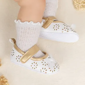 Detail of baby princess shoes with gold velcro straps, white bows and lace socks