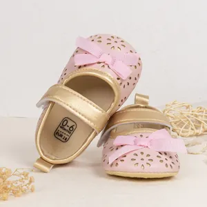 Detailed macro view of baby princess shoes with laser-cut floral patterns and bow
