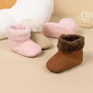 Close-up of baby warm boots with soft suede and plush lining in pink, beige, and brown
