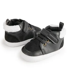 Detail view of winter baby shoes with black faux leather and warm white plush lining
