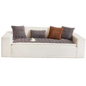 Thick plush grey sofa cushion with white pom-poms and matching textured pillows