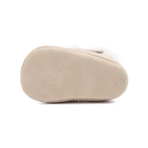 Vue détaillée de la semelle de bottines pour bébé en daim beige avec bordure en fourrure