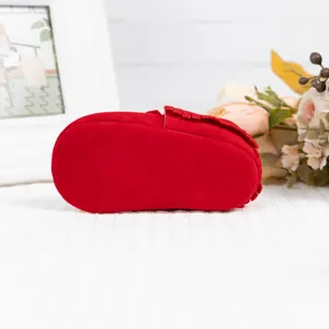 Détails des mocassins pour bébé en daim rouge avec semelles souples et franges