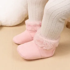 Detailed close-up of pink baby boots with soft soles and warm faux fur collar trim