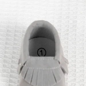 Vue détaillée des bottines grises pour bébé avec franges et semelle souple confortable