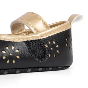 Detail of baby princess shoes with gold hollow flower pattern and velcro strap