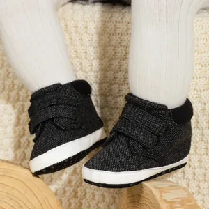 Close-up of baby high-top soft sole shoes with grey tweed fabric and velcro closure