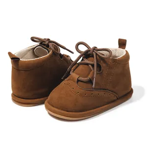 Detailed side view of brown faux suede baby boots with brogue perforations and laces