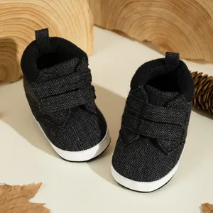 Deep grey knit high-top baby shoes with double velcro straps on white flat soles