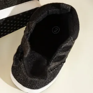 Close-up of baby high-top canvas shoes showing the soft black interior and size marking