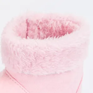 Close-up of pink baby boot showing soft plush lining and suede texture detail