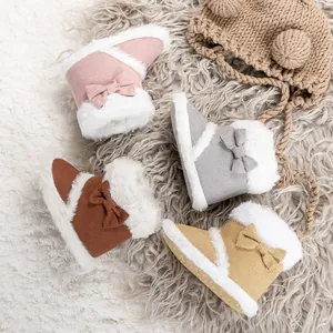 Detailed view of winter baby boots in pink, grey, and brown with faux fur and bow accents