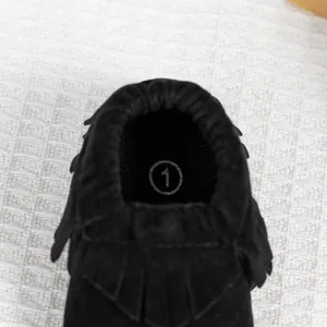 Mocassins pour bébé noirs à franges avec semelles souples vus de dessus en gros plan