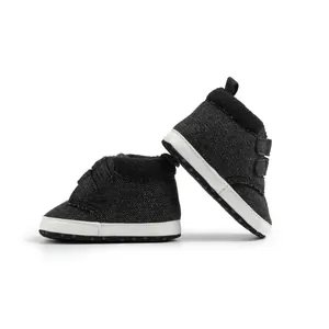 Detail view of woven fabric baby sneakers with soft white soles and velcro straps