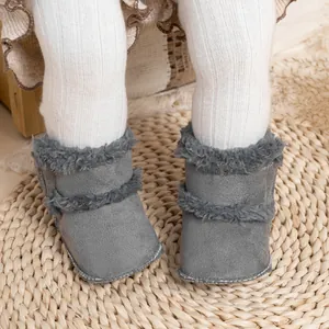 Gros plan de bottines d'hiver grises pour bébé avec bordure en peluche et coutures