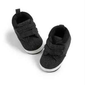Detail of dark grey infant shoes with canvas texture and double hook-and-loop straps