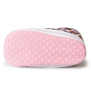 Dettaglio scarpe neonato leopardate con suole morbide rosa antiscivolo dotate di gommini