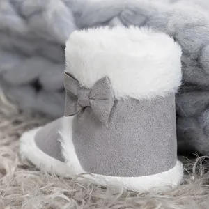 Detailed view of baby snow boots with soft grey suede, plush faux fur, and cute side bow