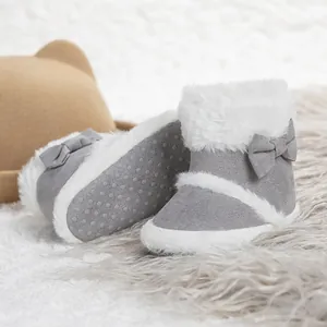 Detail of warm baby winter boots with grey suede, white faux fur and non-slip soles