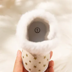Detail of warm baby snow boots with gold stars and soft plush faux fur lining