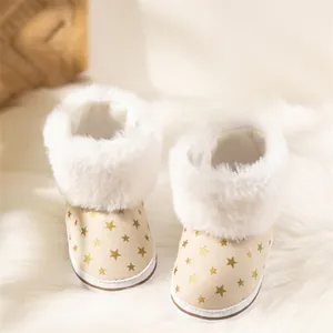 Macro view of baby snow boots with gold star prints and fluffy faux fur trim