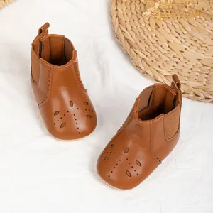 Brown leather baby boots with stylish leaf cut-outs and flexible anti-slip rubber soles