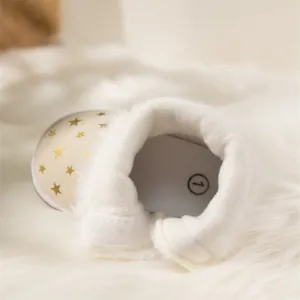 Detail of baby snow boots featuring plush faux fur lining and golden star pattern print