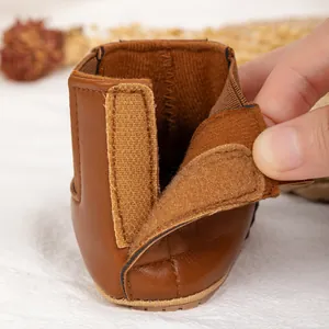 Detail of dark brown leather baby boots with warm lining and velcro fastener closure