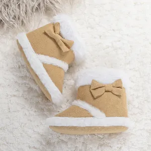 Detail of baby winter boots with warm plush lining and cute bow on soft khaki fabric