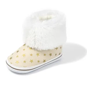 Detail of baby snow boot with gold star print, plush faux fur trim and soft beige upper