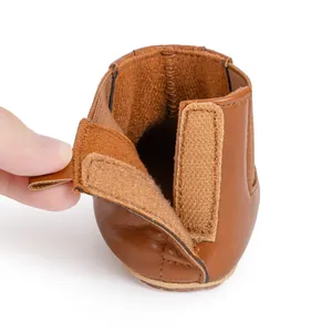Detail showing the brown leather baby shoe interior and adjustable velcro strap closure