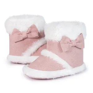 Detailed view of pink baby boots with plush white faux fur trim and bow decorations