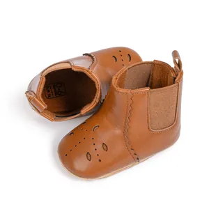 Close-up of brown baby Chelsea boots with laser-cut hollow patterns and size marks