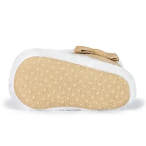 Detailed macro view of the non-slip dotted sole on khaki baby boots with fur lining