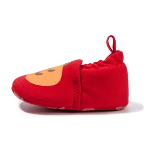 Detail of red baby walking shoe with cartoon pumpkin face and secure elastic heel