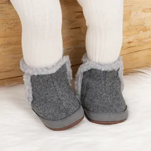 Primer plano de botas de invierno para bebé con forro de felpa gris y suela antideslizante