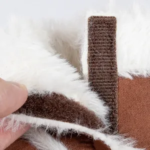 Detailed close-up of brown suede baby boots with warm white faux fur lining and velcro strap