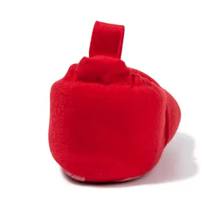 Detail of red knit fabric texture and pull tab on soft sole infant walking shoes
