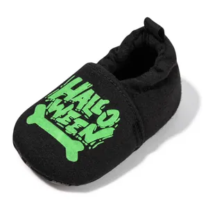 Detail of baby Halloween soft-sole shoes featuring green bone print and elastic cuff