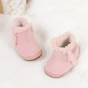 Detalle de botas de nieve rosas para bebé con forro de felpa y costura limpia