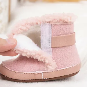 Detalle de bota de nieve rosa para bebé con forro de felpa suave y cierre de velcro