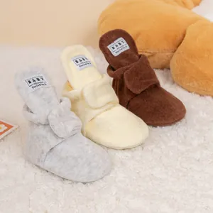 Detailed view of warm fleece baby walking boots in grey, yellow, and brown tones