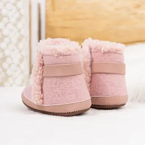 Primer plano detallado de botas de invierno rosas para bebé con ribete de felpa suave