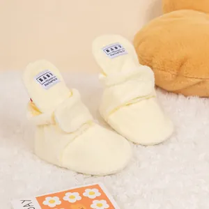 Detailed view of warm plush baby winter boots with soft coral fleece and a woven label
