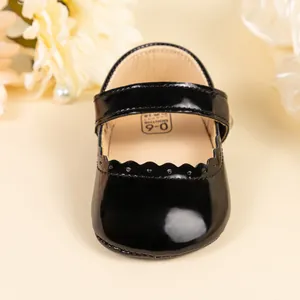 Détails des chaussures bébé Mary Jane en cuir verni noir avec bords découpés ondulés