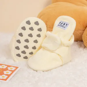 Detail of beige baby walking shoes with anti-slip cloud pattern soles and warm fleece fabric