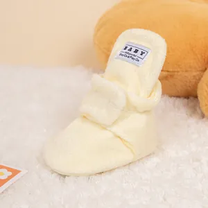 Close-up of yellow plush baby winter shoes with soft fleece texture and warm lining